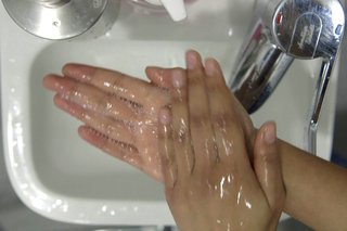 image of rubbing hands together over the sink