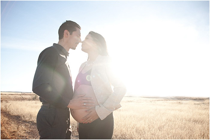 Dreamy maternity photo shoot of the father holding his wifes belly in cornfields