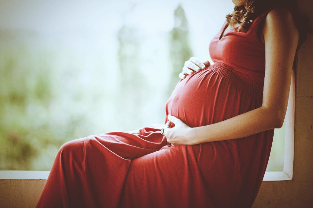 Беременная девушка в красном платье