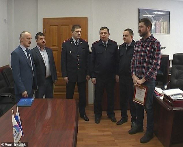 Gleb Sizykh (far right) received his honour from the local police force for intervening
