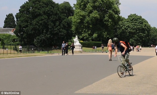 This cyclist almost caused himself an injury gawking at the model walking through Hyde Park