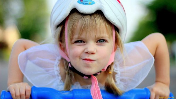 Девочка в шлеме едет на велосипеде
