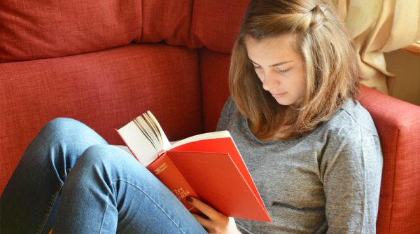 Девочка-подросток читает книгу