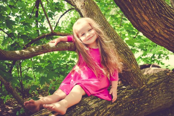 Девочка сидит на дереве