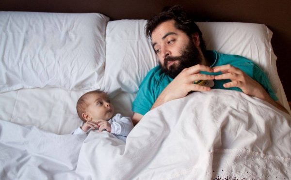 Мужчина с ребёнком лежат в кровати